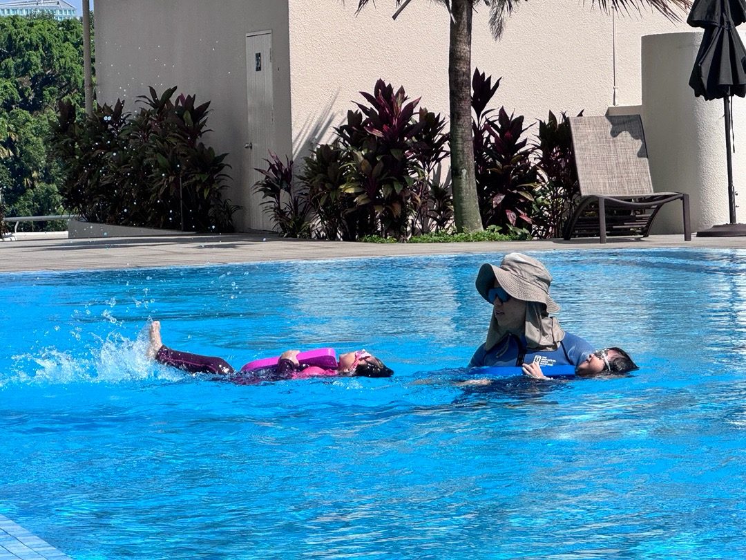 Instructor guiding a child during a swimming lesson in the pool