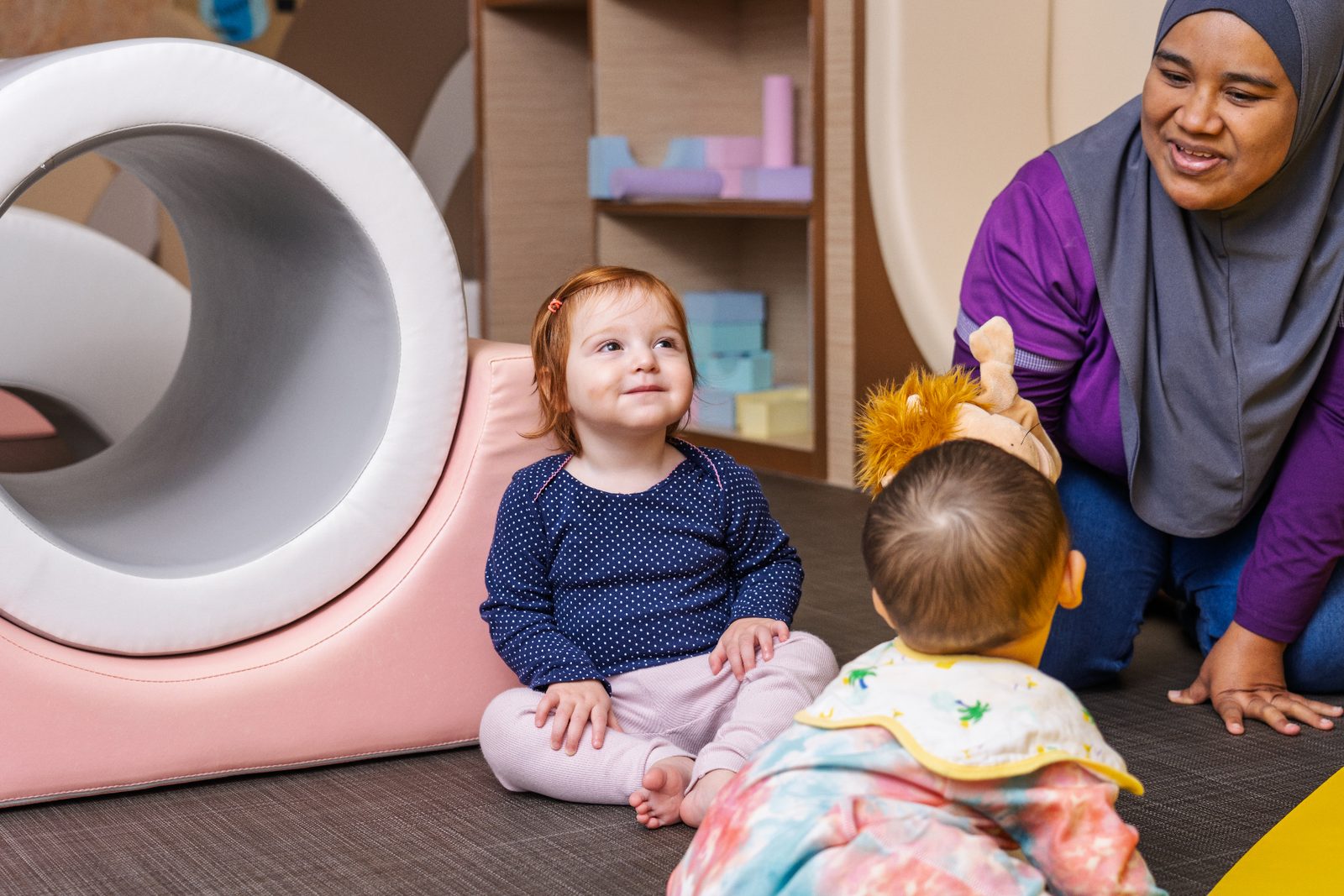 An educator engaging warmly with infants during play